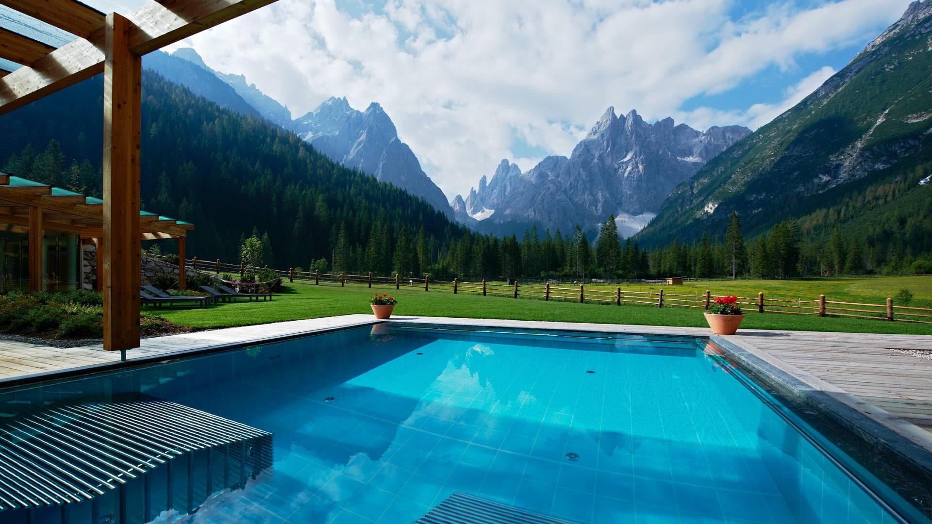 La piscina esterna con piattaforme idromassaggio e vista sulle Dolomiti
