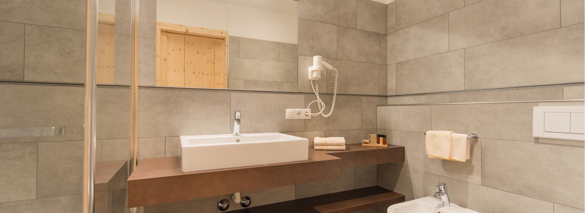 Bathroom of the double room Sepp Innerkofler South with shower, washbasin, bidet and toilet