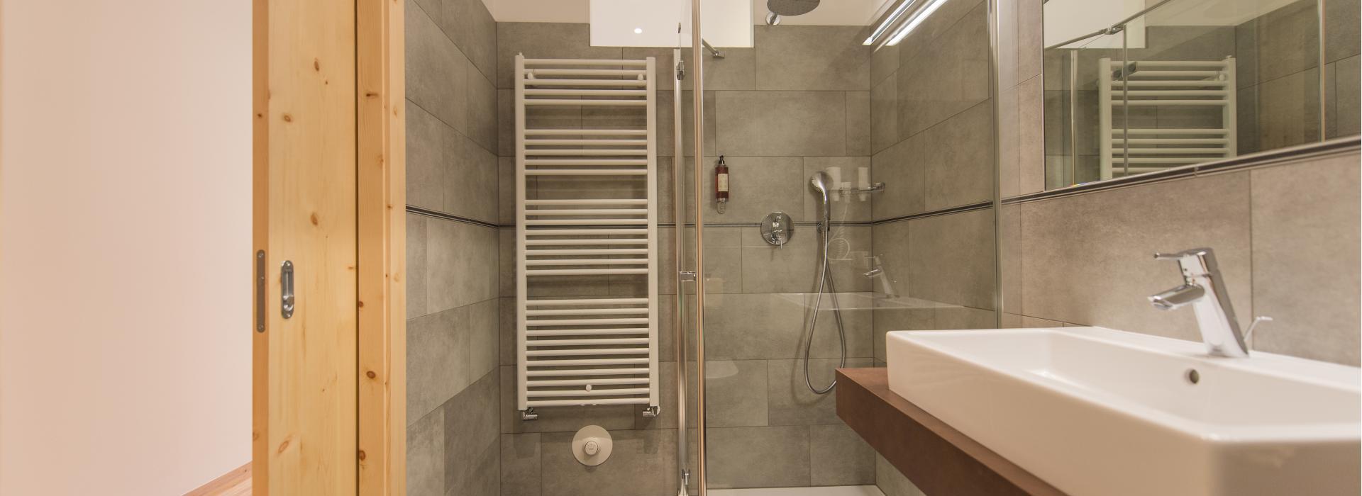 Badezimmer des Doppelzimmers Sepp Innerkofler Süd mit Dusche und Waschtisch