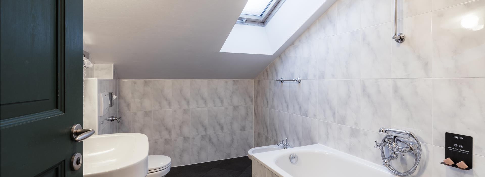 Bathroom of the Superior South Chalet with bathtub, washbasin, bidet, WC and skylight